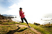 Woman trail running along the Oregon coast Cannon Beach, Oregon, USA