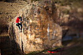 A rock climber works on bouldering problem in Colorado Vail, Colorado, USA