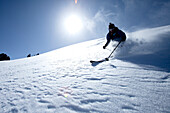 Low angle perspective of one man telemark skiing on a blue sky day Wendover, Nevada, USA