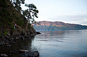 A young adult on a rope swing at sunset in Idaho Sandpoint, Idaho, USA