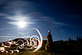 Rock cairn with light painting next to it and full moon in background in Idaho Sandpoint, Idaho, USA