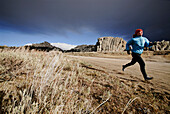 A woman running along a dirt road City of Rocks, Idaho, USA