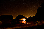 A tent illuminates the night with a star filled sky Joshua Tree, California, USA