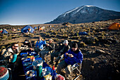 A team of hikers have a nice breakfast at sunrise about 1000 ft. below the summit of Mt. Kilimanjaro Tanzania