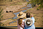 A couple points out wildlife from a viewing area above a river bottom in Terengerie National Park Tanzania