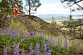 Young woman does yoga in nature overlooking a large lake Sandpoint, Idaho, USA