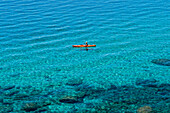 A single kayaker is out for a morning paddle on the pristine shores of Lake Tahoe, Nevada Incline Village, Nevada, USA