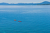 A pair of kayakers is out for a morning paddle on the pristine water of Lake Tahoe, Nevada Incline Village, Nevada, USA