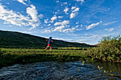 A young woman enjoys the evening light and empty trail during an evening trail run in Lake Tahoe, Nevada Incline Village, Nevada, USA