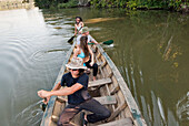 A group of young people paddling a canoe and having fun on lake sandoval Sandoval Lake, Amazon Rainforest, Puerto Maldanado, Peru, Peru