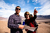 Two male hikers look over a map while backpacking through the Confidence Hills in Death Valley Nation Park, California Death Valley, California, United States of America