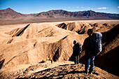 Two male hikers search to find the best route through Death Valley's Confidence Hills, in California, while on backing packing Death Valley, California, United States of America