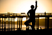 A silhouetted woman does yoga on the beach in Ventura, California Ventura, California, United States of America
