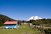 Volcan Lonquimay and a blue farm house in the Andes mountains of Chile, Volcan Lonquimay, Chile