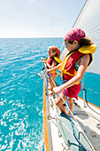 Two young girls on the bow during a day sail in Georgetown, Exumas, Georgetown, Exumas, Bahamas