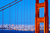 A detail of the Golden Gate Bridge at dusk with San Francisco in the background, California San Francisco, California, USA