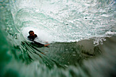 A male bodysurfer gets barreled while bodysurfing at Zuma beach in Malibu, California Malibu, California, United States of America