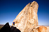 Two male climbers work their way up Headstone Rock in Joshua Tree National Park, California Joshua Tree, California, United States of America