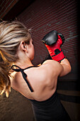 A teenage girl puts on a boxing glove before training for mixed martial arts outside a warehouse in Birmingham, Alabama Birmingham, Alabama, United States