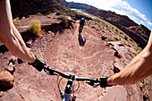 Mountain bikers riding on a trail overlooking the Colorado River near Moab Utah Moab, Utah, USA