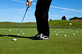 Man lining up a putt while golfing Portland, Oregon, USA