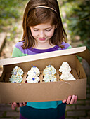 girl holds box of cupcakes, portland, me, usa