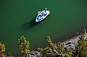 A man coils his wakeboard rope as his sexy girlfriend drives the boat. Shot from above in Idaho Sandpoint, Idaho, USA