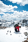 A skier buckles his boots on the summit of Kachina Peak at Taos Ski Valley, New Mexico New Mexico, USA