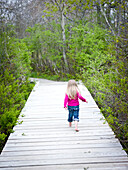 young girl walks across a bridge near the ocean in cape elizabeth, me cape elizabeth, me, usa