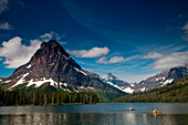 A kayaker on a lake with a dramatic background in the distance Montana, USA