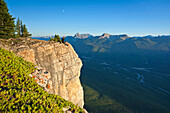 A hiker sits on a cliff edge, Banff National Park, Alberta, Canada Alberta, Canada