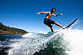 A athletic young man wakesurfing on a sunny day in Idaho., Sandpoint, Idaho, USA