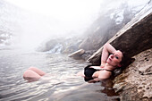 A beautiful woman relaxing in a hot springs waterfall in Montana., Bozeman, Montana, USA