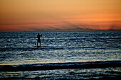 A male enjoying an evening stand up paddle board session with the last light of the day. Baja Mexico.(silhouette), Baja, Mexico