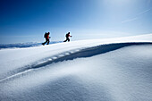 Two backcountry skiers hiking in fresh powder and bluebird skies., Park City, Utah, USA