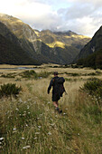 Male hiker at sunset on trail, South Island, New Zealand