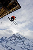 A young man skis off the roof of an alpine hut in Grindalwald, Switzerland Grindelwald, Jungfrau region, Switzerland