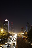 Night shot of urban traffic on ring road, skyscrapers in background, Guomao district, Beijing, China