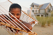 African woman laying in hammock at beach, Norfolk, VA