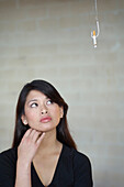 Asian woman looking at cigarette on hook, Richmond, VA
