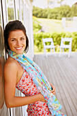 Young woman leaning against glass door, Cape Cod, MA