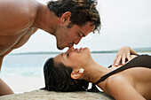 South American man kissing girlfriend on nose, Morrocoy, Venezuela