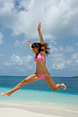 Young woman jumping at beach, Morrocoy, Venezuela