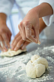 Close up of baker sprinkling flour on dough, Orlando, FL