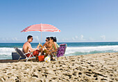Hispanic friends relaxing at beach, Caruao, Venezuela