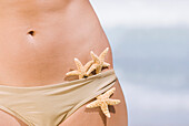 Starfish tucked into woman's bikini bottoms, Caruao, Venezuela