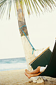 Hispanic man laying in hammock at beach, Chorroni, Venezuela