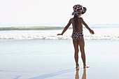 Young mixed race girl standing at beach, Venice Beach, CA