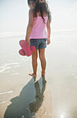 Hispanic girl walking on beach, Rockaway Beach, NY