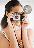 Mixed race woman using old-fashioned camera, Jersey City, New Jersey